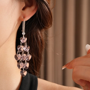Detail of pink heart crystal tassel earrings with sparkling cubic zirconia on model