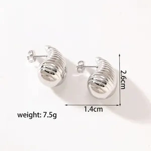 Macro shot of silver titanium hollow earrings with horizontal spiral texture detail