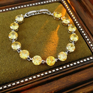 Macro detail of royal style bracelet with round yellow zircon stones and silver clasp