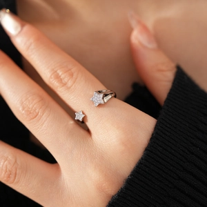 Détail d'une bague étoile plaquée or 18 carats avec zircons sur la main d'un modèle
