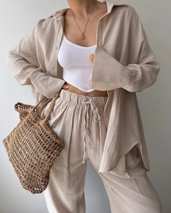 Detail of minimalist beige linen shirt and matching drawstring wide-leg trousers