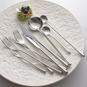 Polished 304 stainless steel cutlery set with long handles arranged on a white plate