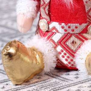 Detail of red velvet Christmas gnome with gold sequins and soft faux fur trim