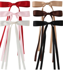 Detailed flat lay of colorful silk bow hair clips in red, pink, beige, and black