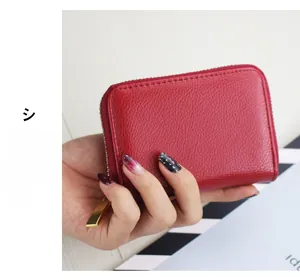 Detail of red lychee grain leather wallet with golden zipper showing the compact size