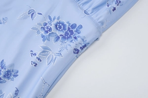 Detaillierte Nahaufnahme von hellblauem Blumenstoff mit Netztextur und präzisen Nähten