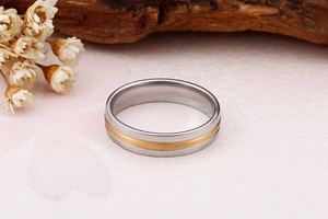 Vue macro d'une bague en acier inoxydable brossé bicolore avec centre doré