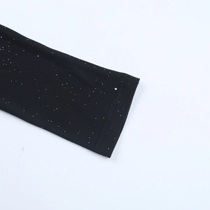 Détail de la manche à paillettes sur robe noire avec paillettes argentées et coutures