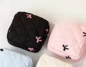 Flat lay of quilted sanitary napkin bags in various colors with cute bow embroidery