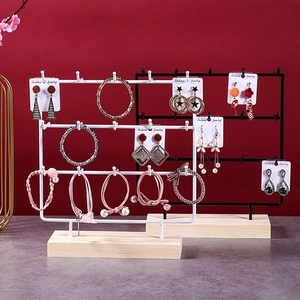 Detail view of multi-layer metal jewelry organizer with natural wood base in black and white