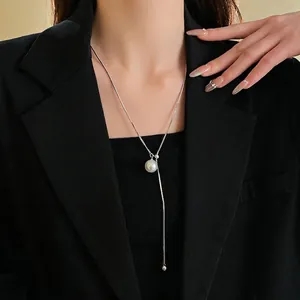 Minimalist silver snake chain necklace featuring a round white pearl pendant on a model