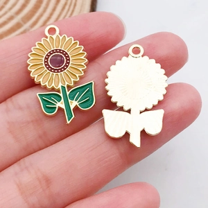 Détail des breloques tournesol jaune avec finition émaillée et dos en métal doré