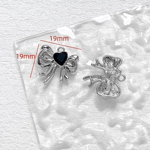 Makro-Detail von 19mm silbernen Schleifen-Anhängern mit schwarzem Herz für DIY-Schmuck