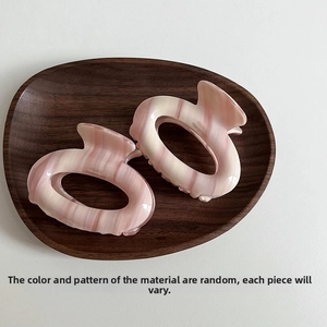 Detail of pink marble acetate hair claw clips with France Handmade engraving on wood tray