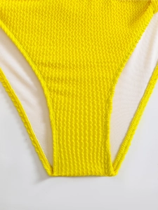 Detail of yellow wave-textured bikini fabric with soft white lining and elastic structure