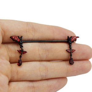 Detail view of black bat nipple ring with red oil-drop wings and water-drop pendant