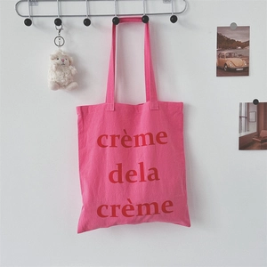 Detail der rosa Canvas-Einkaufstasche mit rotem Buchstabendruck und zwei Tragegriffen