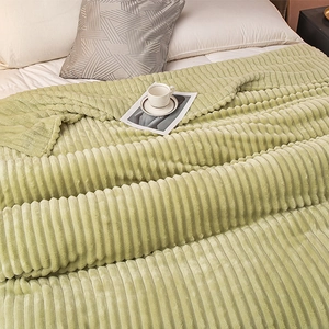 Detalle de una manta de forro polar a rayas verde claro con suave textura de felpa