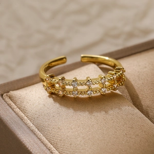 Macro shot of double-row grid gold ring with white zircon stones on jewelry cushion