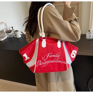 Detail of red bowling tote bag with white embroidery and mesh trim on model