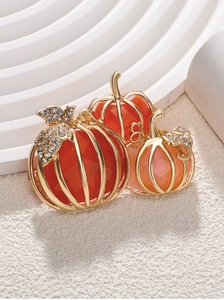 Detailed view of pumpkin brooch featuring orange gems and crystal-encrusted leaves