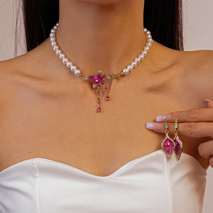 Close-up of pearl necklace with floral crystal pendant and matching drop earrings set