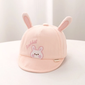 Detail of pink corduroy baby hat featuring cute plush 3D rabbit ears and embroidery