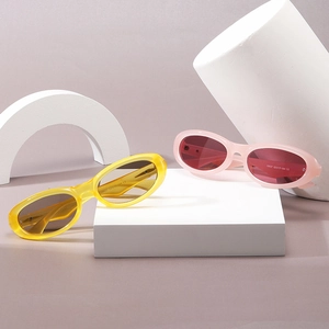 Modern oval contrast-color sunglasses in yellow and pink on geometric display