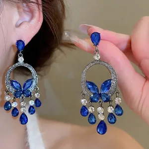 Silver needle drop earrings with blue butterflies and cascading crystal tassels