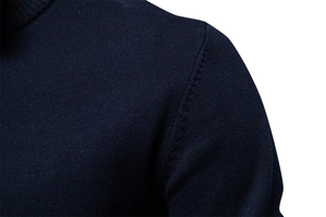 Détail de la couture d'épaule sur un pull en maille bleu marine à coupe ajustée