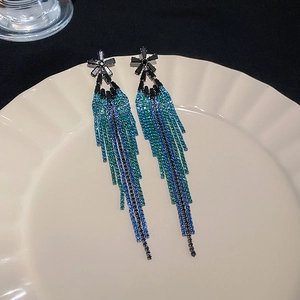 Vintage crystal flower tassel drop earrings in blue gradient on a porcelain tray