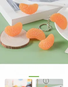 Close-up of realistic PVC orange slice pendant with metal keychain on wooden base