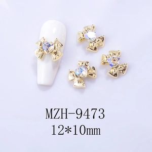 Detailed macro view of 12x10mm golden bow nail charms with heart-shaped iridescent rhinestones
