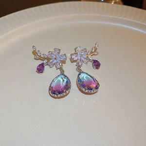 Detailed shot of branch flower earrings with blue-purple gradient crystal drop pendants