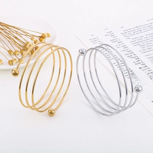 Detail of multi-layer spiral stainless steel bangles in gold and silver finish
