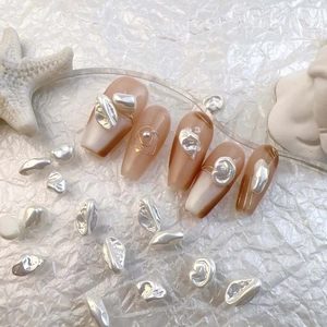 Baroque pearl nail art charms on long trapezoid nude nails with silver metallic accents