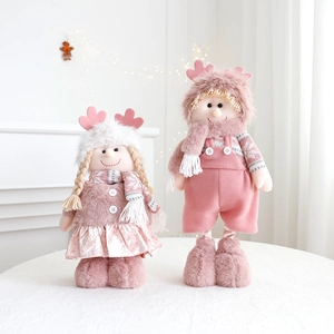 Pink Christmas plush doll set featuring standing boy and girl figures on white tabletop decor