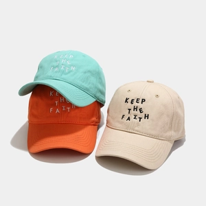 Three minimalist cotton baseball caps in mint green, orange, and beige with letter embroidery