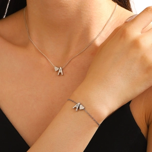Parure collier et bracelet argenté avec pendentif cœur et lettre A portée par mannequin