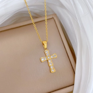 Macro view of gold-plated titanium steel cross pendant necklace with sparkling zircons