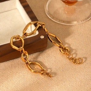 Gold irregular geometric stainless steel chain bracelet on a dark wooden jewelry box