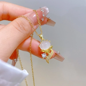Detail of fox pendant with white cat-eye stone and sparkling zircons on gold chain