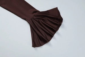 Détail de robe marron foncé avec des manches cloches évasées élégantes et des volants
