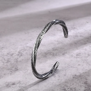 Macro shot of silver-toned vintage feather textured cuff bracelet for men