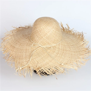 Wide brim raffia sun hat with frayed edges and wooden bead bow tie for beach holidays