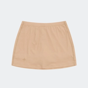 Detail of beige mini skirt with elastic waistband and a cross logo on the front hem