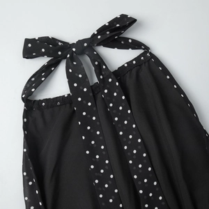 Detail of black polka dot halter neckline with a stylish bow tie on lightweight fabric