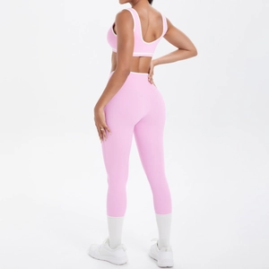 Details des rosa Yoga-Sets mit überkreuztem Taillendesign und weißen Kontrastpaspeln