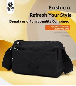Detail of black nylon multi-pocket crossbody bag with wide canvas strap and zip layers