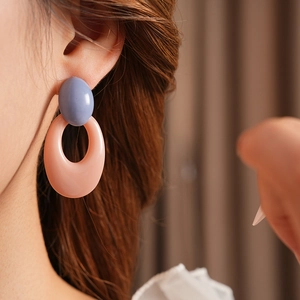 Close-up of minimalist retro hollow oval earrings with blue and pink resin color blocking